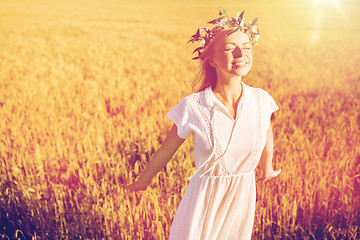 Image showing happy young woman in flower wreath on cereal field