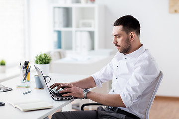 Image showing businessman typing on laptop at office