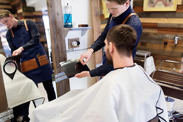 Image showing barber showing tablet pc to man at barbershop