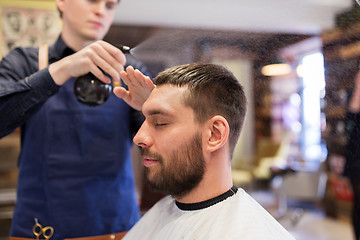 Image showing barber applying styling spray to male hair