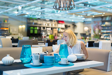 Image showing Woman choosing the right decor for her apartment in a modern home furnishings store.