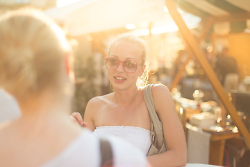 Image showing Female friends enjoying a conversation on market.