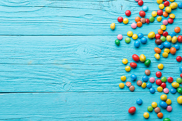 Image showing Multicolored candy on wooden table
