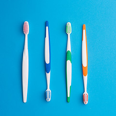 Image showing Multicolored toothbrushes on blue background