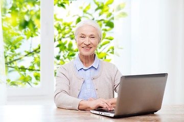 Image showing happy senior woman with laptop at home