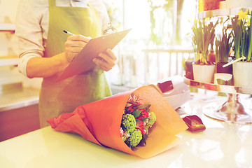 Image showing close up of man with clipboard at flower shop