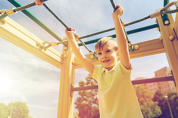 Image showing happy little boy climbing on children playground