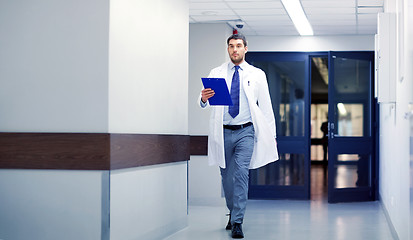 Image showing doctor with clipboard walking along hospital