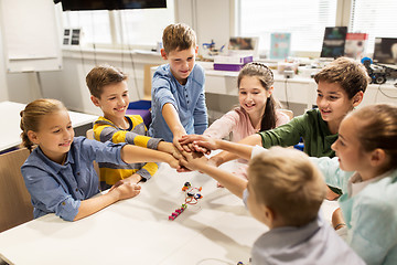Image showing happy children holding hands at robotics school