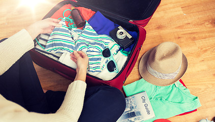 Image showing close up of woman packing travel bag for vacation