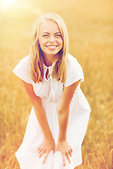 Image showing smiling young woman in white dress on cereal field