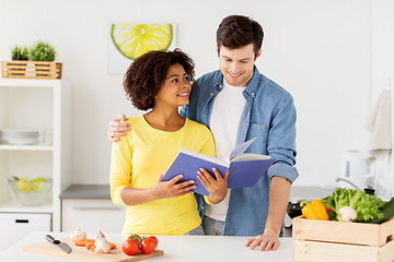 Image showing happy couple with cooking book at home kitchen