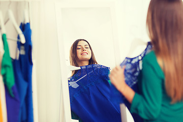 Image showing happy woman choosing clothes at home wardrobe