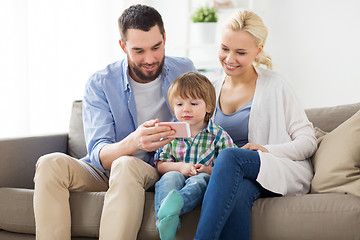 Image showing happy family with smartphone at home