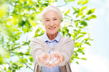 Image showing happy senior woman with medicine at home