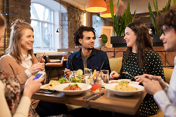 Image showing friends with smartphones eating at restaurant