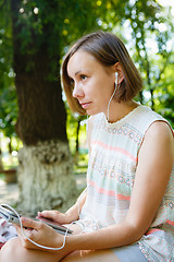 Image showing Charming girl with gadget in park