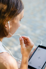 Image showing Woman using headphones with tablet