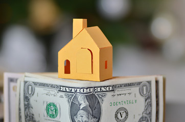 Image showing Miniature paper made house stand on  money