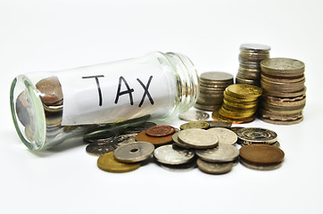 Image showing Tax lable in a glass jar with coins spilling out