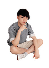 Image showing Young Asian man sitting on floor.