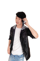 Image showing Asian teenager talking at his cellphone.