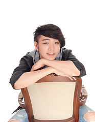 Image showing Asian man sitting backwards on chair.