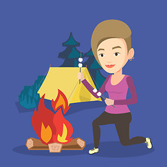 Image showing Woman roasting marshmallow over campfire.