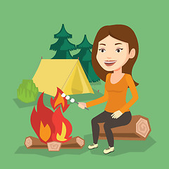 Image showing Woman roasting marshmallow over campfire.