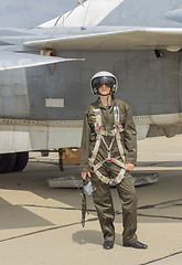 Image showing Military pilot in helmet stands near jet plane