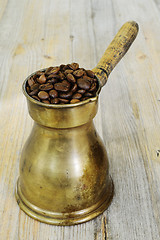 Image showing arabic coffee pot on wooden background with beans