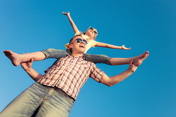 Image showing Dad and daughter in sunglasses playing near a house at the day t