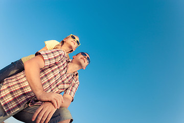 Image showing Dad and daughter in sunglasses playing near a house at the day t