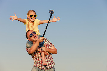 Image showing Dad and daughter in sunglasses playing near a house at the day t