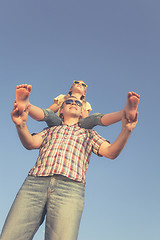 Image showing Dad and daughter in sunglasses playing near a house at the day t