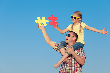 Image showing Dad and daughter in sunglasses playing near a house at the day t