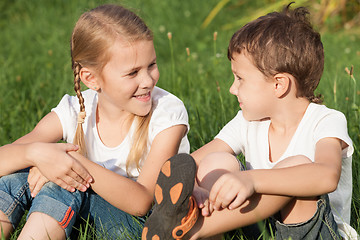 Image showing Two happy children playing near the tree on the grass at the day