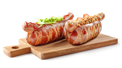 Image showing two hotdogs on wooden cutting board