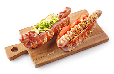 Image showing two hotdogs on wooden cutting board