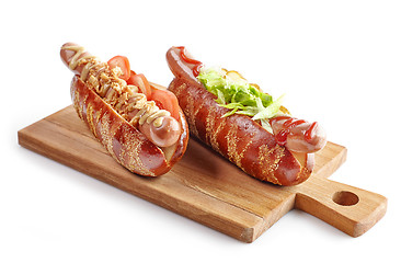 Image showing two hotdogs on wooden cutting board