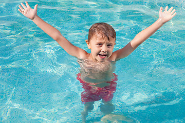 Image showing one happy child playing on the swimming pool at the day time.