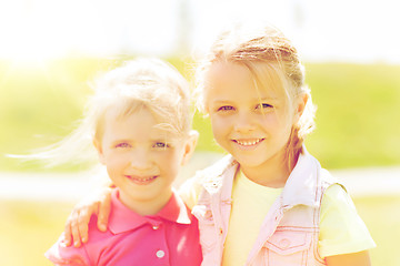 Image showing happy little girls hugging outdoors at summer