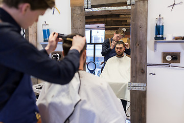 Image showing man and barber cutting hair at barbershop