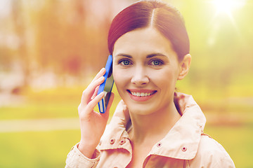 Image showing smiling woman calling on smartphone in park