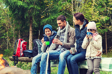 Image showing happy family sitting on bench at camp fire