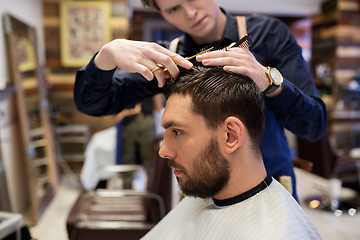 Image showing man and barber cutting hair at barbershop