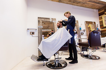 Image showing man and barber cutting hair at barbershop