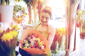 Image showing smiling florist woman with bunch at flower shop