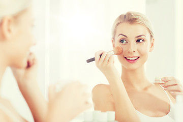 Image showing woman with makeup brush and powder at bathroom