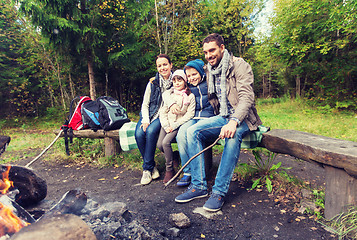 Image showing happy family sitting on bench at camp fire